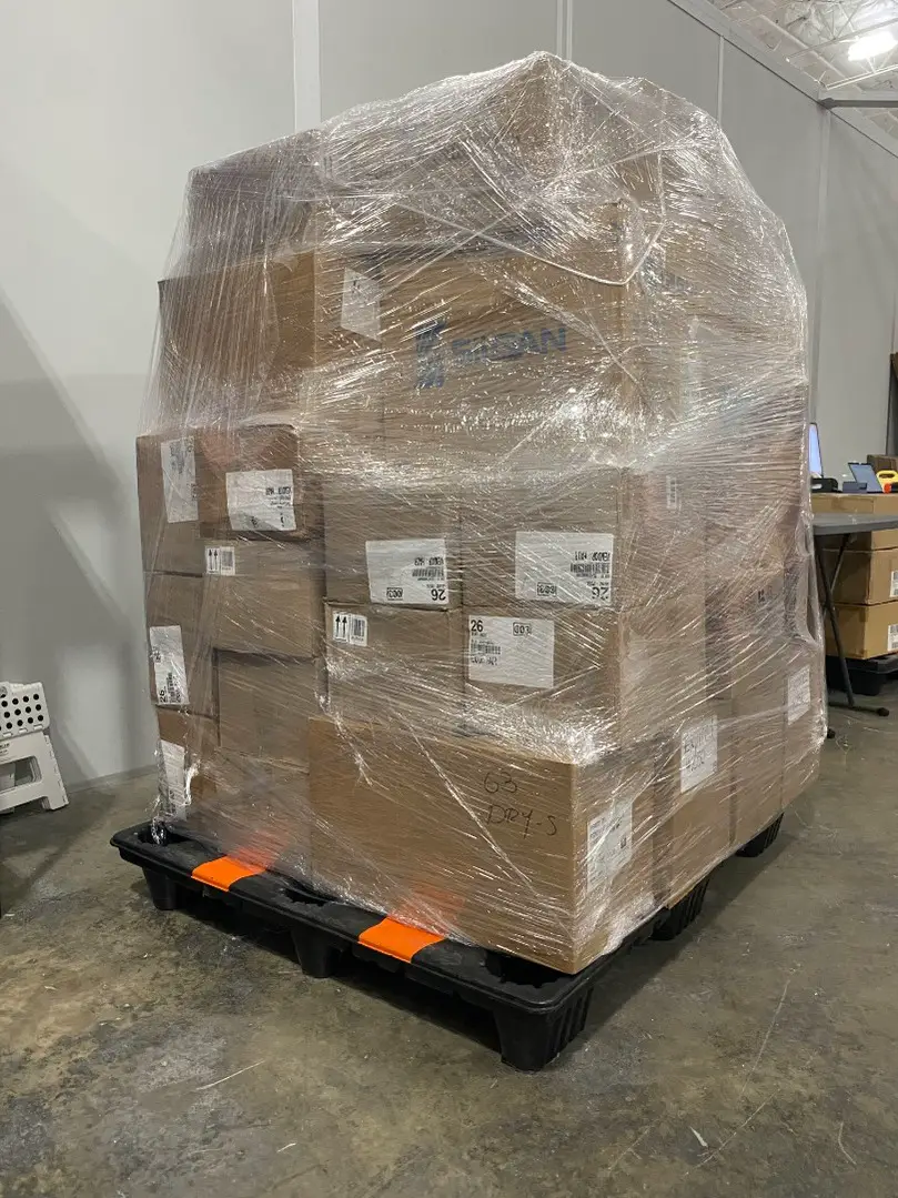 Shrink-wrapped wholesale pallet of assorted shelf-pull makeup in the SourceGrid Doral warehouse