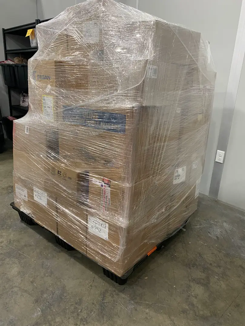 Full wholesale cosmetics pallet on a black plastic pallet ready for pickup