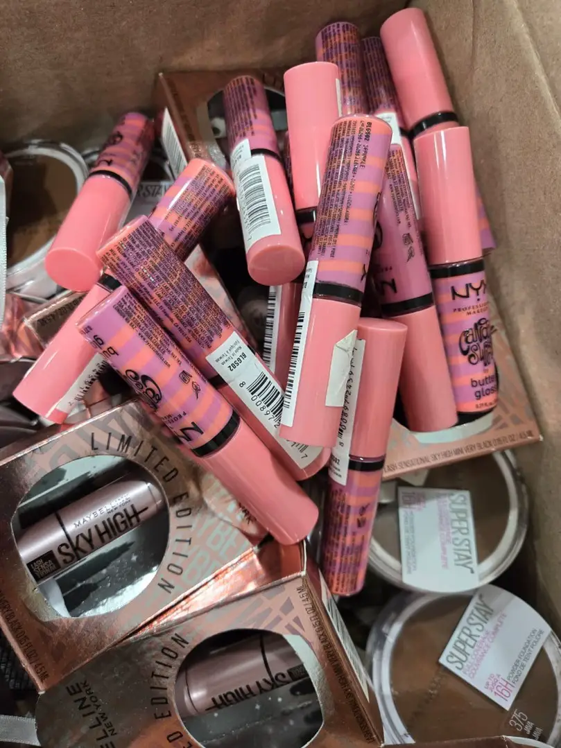 Assorted NYX and Maybelline lip products loose inside a wholesale case